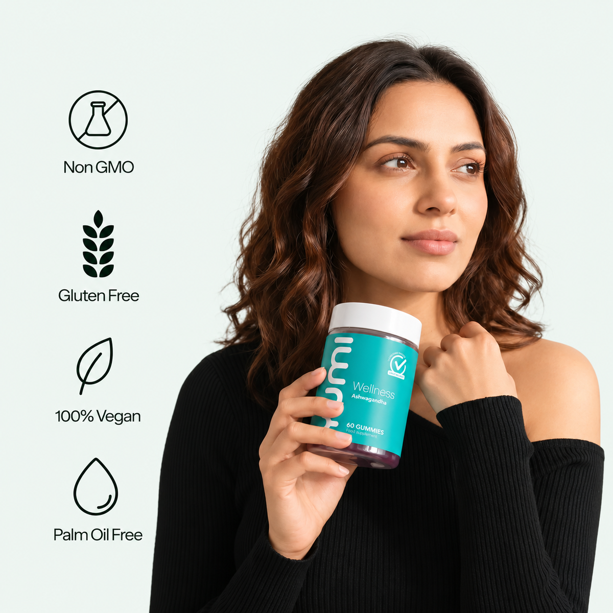 Woman in black top holding Yumi Ashwagandha gummies bottle with Non GMO, Gluten Free, 100% Vegan, and Palm Oil Free icons